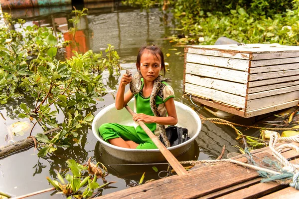 Lake Tonle Sap, Combodia - 28 Eylül 2014: Tanımlanamayan Vietnamlı kız, Güneydoğu Asya'nın en büyük tatlı su gölü olan Tonle Sap Gölü'nde leğen kemiğinde bir yılanla yelken açar.