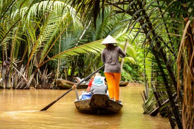 Song Nuoc Mien Tay, Vietnam - Eki 5, 2014: Tanımlanamayan Vietnamlı kadın Mekong nehri üzerinde turistlerle bir tekne yelken. Mekong dünyanın en uzun 12.