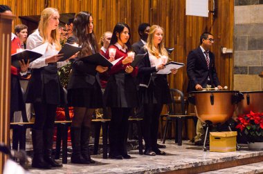 Lugano, İsviçre - 6 Aralık 2015: Kimliği belirsiz çocuklar kilisede bir Noel şarkısı söylüyor. Bilinen ilk Noel ilahileri dördüncü yüzyıl Roma'sında ortaya çıktı