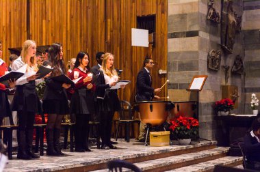 Lugano, İsviçre - 6 Aralık 2015: Kimliği belirsiz çocuklar kilisede bir Noel şarkısı söylüyor. Bilinen ilk Noel ilahileri dördüncü yüzyıl Roma'sında ortaya çıktı