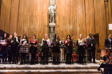 Lugano, İsviçre - 6 Aralık 2015: Kimliği belirsiz çocuklar kilisede bir Noel şarkısı söylüyor. Bilinen ilk Noel ilahileri dördüncü yüzyıl Roma'sında ortaya çıktı