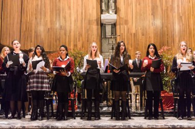 Lugano, İsviçre - 6 Aralık 2015: Kimliği belirsiz çocuklar kilisede bir Noel şarkısı söylüyor. Bilinen ilk Noel ilahileri dördüncü yüzyıl Roma'sında ortaya çıktı