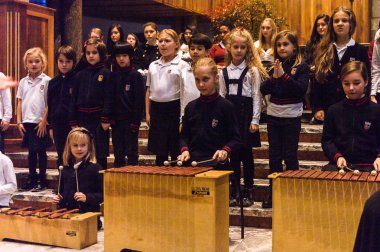 Lugano, İsviçre - 6 Aralık 2015: Kimliği belirsiz çocuklar kilisede bir Noel şarkısı söylüyor. Bilinen ilk Noel ilahileri dördüncü yüzyıl Roma'sında ortaya çıktı