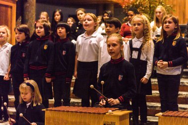 Lugano, İsviçre - 6 Aralık 2015: Kimliği belirsiz çocuklar kilisede bir Noel şarkısı söylüyor. Bilinen ilk Noel ilahileri dördüncü yüzyıl Roma'sında ortaya çıktı
