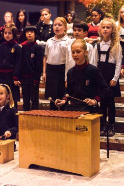 Lugano, İsviçre - 6 Aralık 2015: Kimliği belirsiz çocuklar kilisede bir Noel şarkısı söylüyor. Bilinen ilk Noel ilahileri dördüncü yüzyıl Roma'sında ortaya çıktı