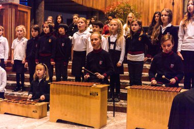 Lugano, İsviçre - 6 Aralık 2015: Kimliği belirsiz çocuklar kilisede bir Noel şarkısı söylüyor. Bilinen ilk Noel ilahileri dördüncü yüzyıl Roma'sında ortaya çıktı