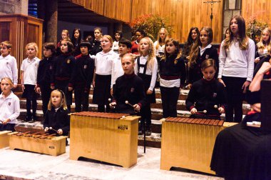 Lugano, İsviçre - 6 Aralık 2015: Kimliği belirsiz çocuklar kilisede bir Noel şarkısı söylüyor. Bilinen ilk Noel ilahileri dördüncü yüzyıl Roma'sında ortaya çıktı