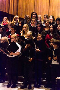 Lugano, İsviçre - 6 Aralık 2015: Kimliği belirsiz çocuklar kilisede bir Noel şarkısı söylüyor. Bilinen ilk Noel ilahileri dördüncü yüzyıl Roma'sında ortaya çıktı