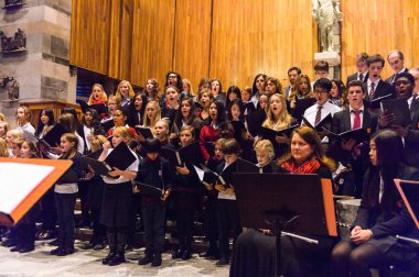 Lugano, İsviçre - 6 Aralık 2015: Kimliği belirsiz çocuklar kilisede bir Noel şarkısı söylüyor. Bilinen ilk Noel ilahileri dördüncü yüzyıl Roma'sında ortaya çıktı
