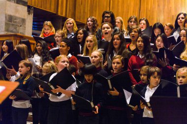 Lugano, İsviçre - 6 Aralık 2015: Kimliği belirsiz çocuklar kilisede bir Noel şarkısı söylüyor. Bilinen ilk Noel ilahileri dördüncü yüzyıl Roma'sında ortaya çıktı