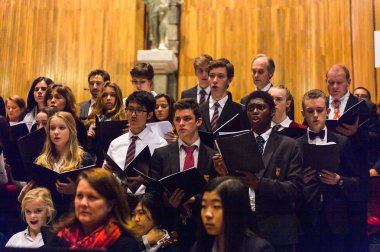 Lugano, İsviçre - 6 Aralık 2015: Kimliği belirsiz çocuklar kilisede bir Noel şarkısı söylüyor. Bilinen ilk Noel ilahileri dördüncü yüzyıl Roma'sında ortaya çıktı