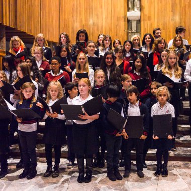 Lugano, İsviçre - 6 Aralık 2015: Kimliği belirsiz çocuklar kilisede bir Noel şarkısı söylüyor. Bilinen ilk Noel ilahileri dördüncü yüzyıl Roma'sında ortaya çıktı