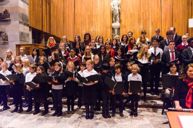Lugano, İsviçre - 6 Aralık 2015: Kimliği belirsiz çocuklar kilisede bir Noel şarkısı söylüyor. Bilinen ilk Noel ilahileri dördüncü yüzyıl Roma'sında ortaya çıktı