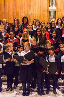 Lugano, İsviçre - 6 Aralık 2015: Kimliği belirsiz çocuklar kilisede bir Noel şarkısı söylüyor. Bilinen ilk Noel ilahileri dördüncü yüzyıl Roma'sında ortaya çıktı