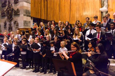 Lugano, İsviçre - 6 Aralık 2015: Kimliği belirsiz çocuklar kilisede bir Noel şarkısı söylüyor. Bilinen ilk Noel ilahileri dördüncü yüzyıl Roma'sında ortaya çıktı