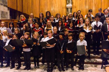 Lugano, İsviçre - 6 Aralık 2015: Kimliği belirsiz çocuklar kilisede bir Noel şarkısı söylüyor. Bilinen ilk Noel ilahileri dördüncü yüzyıl Roma'sında ortaya çıktı