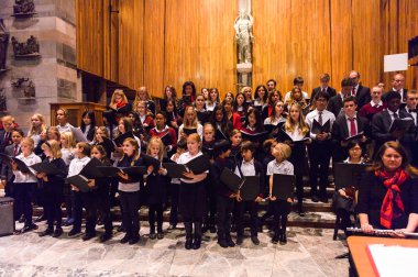 Lugano, İsviçre - 6 Aralık 2015: Kimliği belirsiz çocuklar kilisede bir Noel şarkısı söylüyor. Bilinen ilk Noel ilahileri dördüncü yüzyıl Roma'sında ortaya çıktı