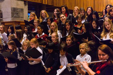 Lugano, İsviçre - 6 Aralık 2015: Kimliği belirsiz çocuklar kilisede bir Noel şarkısı söylüyor. Bilinen ilk Noel ilahileri dördüncü yüzyıl Roma'sında ortaya çıktı
