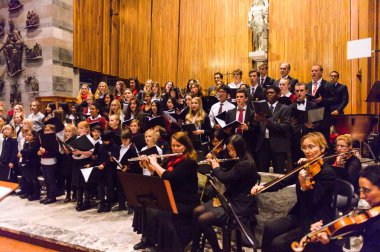 Lugano, İsviçre - 6 Aralık 2015: Kimliği belirsiz çocuklar kilisede bir Noel şarkısı söylüyor. Bilinen ilk Noel ilahileri dördüncü yüzyıl Roma'sında ortaya çıktı