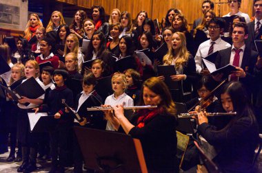 Lugano, İsviçre - 6 Aralık 2015: Kimliği belirsiz çocuklar kilisede bir Noel şarkısı söylüyor. Bilinen ilk Noel ilahileri dördüncü yüzyıl Roma'sında ortaya çıktı