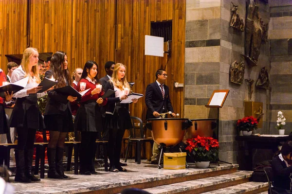 Lugano, İsviçre - 6 Aralık 2015: Kimliği belirsiz çocuklar kilisede bir Noel şarkısı söylüyor. Bilinen ilk Noel ilahileri dördüncü yüzyıl Roma'sında ortaya çıktı