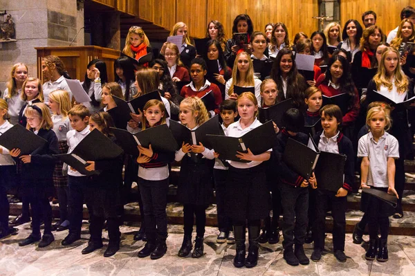 Lugano, İsviçre - 6 Aralık 2015: Kimliği belirsiz çocuklar kilisede bir Noel şarkısı söylüyor. Bilinen ilk Noel ilahileri dördüncü yüzyıl Roma'sında ortaya çıktı