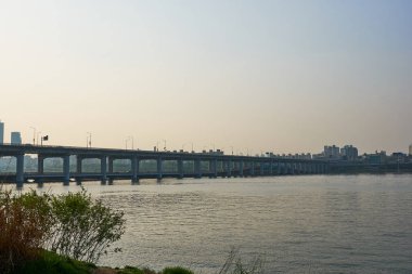 Gün batımı sırasında Seul, Güney Kore 'de Han Nehri 'nde Jamsu Köprüsü manzaralı bir manzara.                                