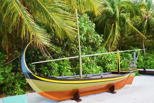 A boat resting on a beach on Maldives island of Coco Bodu Hithi Resort.