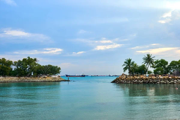 A view of ships resting on the ocean seen from the Siloso Beach, Singapore.