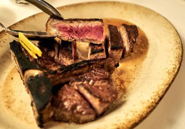 Kaşık arasında düzenlenen lezzetli T-Bone biftekten et sulu bir kısmı.