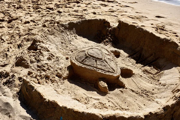 A turtle figure sculpted with sand at the Turtle beach of O\'ahu, Hawaii.