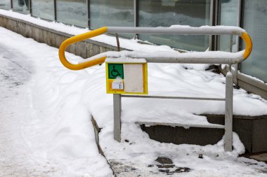Küpeşte ile engelli insanlara yardım etmek için düğme. Yalan kar