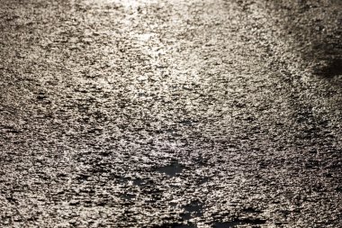 Yağmurdan sonra ıslak asfalt yol. Arka plan asfalt. Asfalt bakış açısı. Güneş yansıması. Arka plan ve doku.