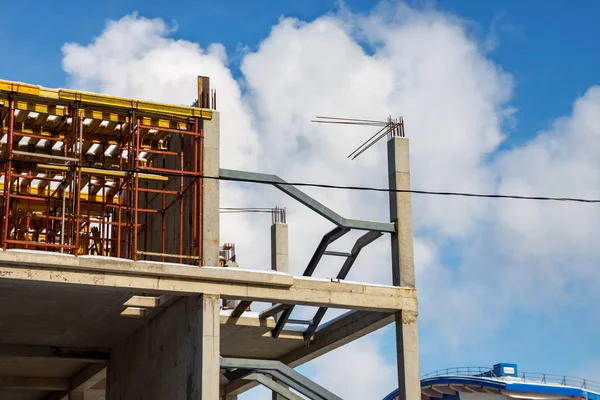 Monolithic construction of multi-storey Parking of concrete on the background of clouds and blue sky. Installation of formwork for concrete floors.