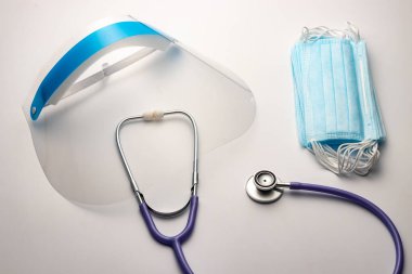 Doktor kişisel koruyucu ekipman konsepti. Stetoskop, yüz kalkanı, maske.