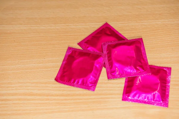 Pink Condom Wooden Table — Stock Photo, Image