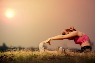 Asyalı kadın alan çim bükme ve parmak dokunmatik ayak, oturan kadın ısınmak kontrast veya egzersiz, hamstring ve gastock nemius kas germe, önce sakin ol kas yaralanması önleme 