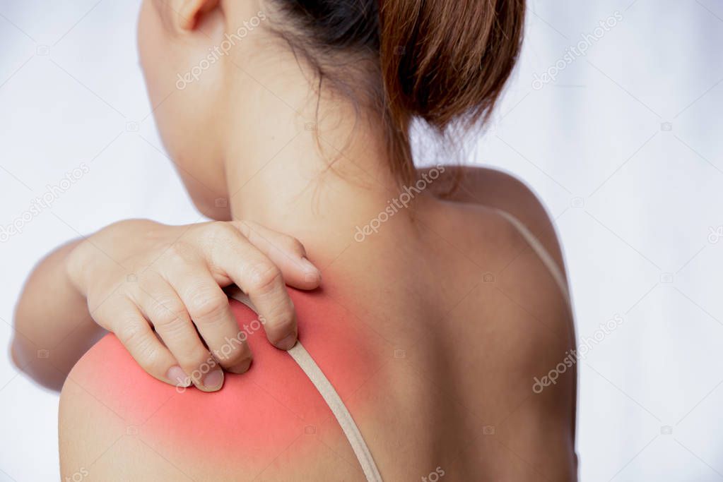 Young woman scratching on skin of left shoulder area, rash at left side of Asian woman