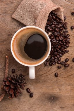 üstten görünüm kahve Kupası ahşap arka plan üzerinde kahve çekirdeği ile 