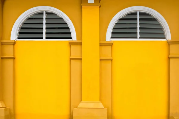 yellow building and haft circle window