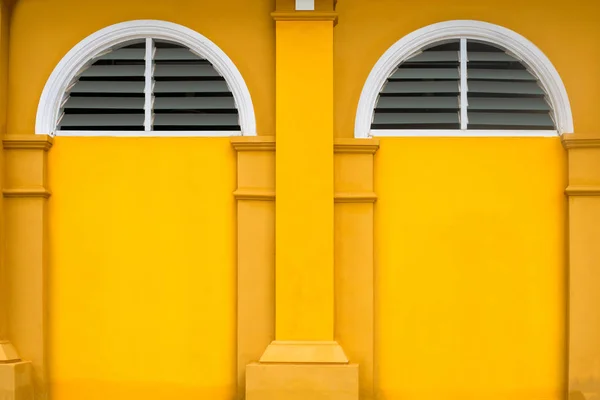 Jaune bâtiment et arbre cercle fenêtre — Photo