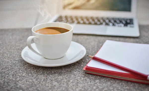 Desfoque xícara de café no chão com notebook e laptop, manhã, ho — Fotografia de Stock