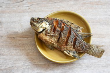 kahverengi seramik plaka ve ahşap arka planlar, spot odak, kopya alanı üzerinde kızarmış balık