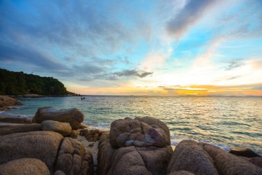 Gün batımında kum ile sahilde deniz ve kaya taşları., doğa deniz sahnesi ve manzara fotoğrafçılığı, huzurlu Rock Beach Sunset