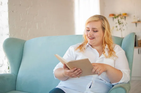 Young overweight woman reads paper book, rest alone, self-development Royalty Free Stock Images