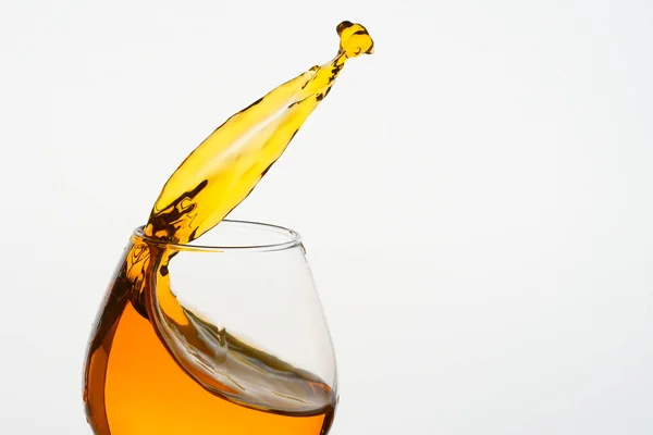 Freeze Action Photography .Splash of Cognac Em vidro isolado em branco . — Fotografia de Stock