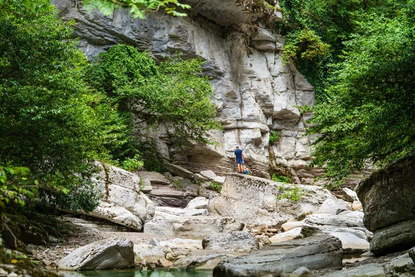 游客们站在森林峡谷里的一块大石头上 — 图库照片