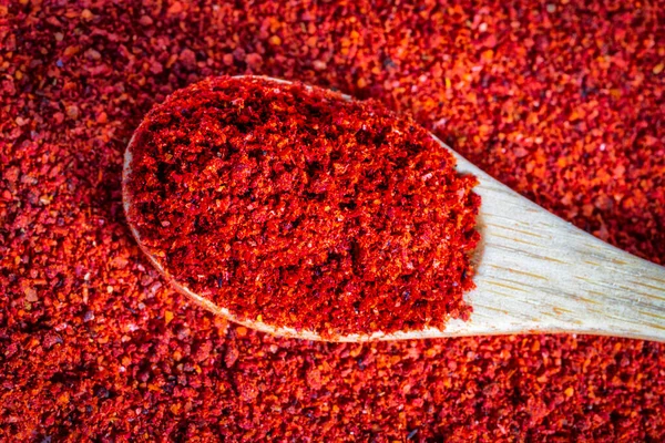 Pila de pimiento rojo picante triturado seco en la cuchara de bambú, fondo de textura de pimentón. — Foto de Stock