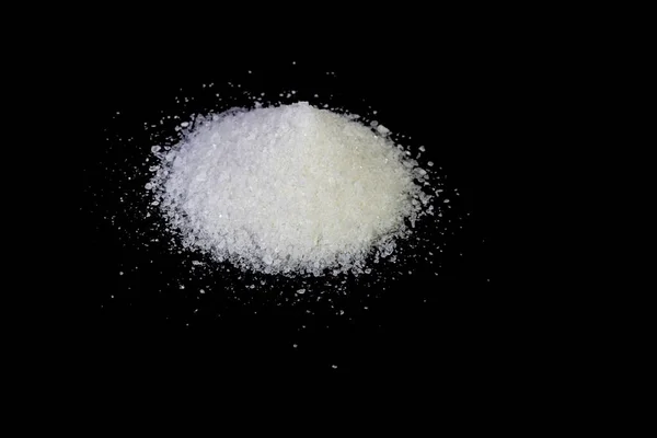 Купа зерна морської солі на чорному тлі — стокове фото
