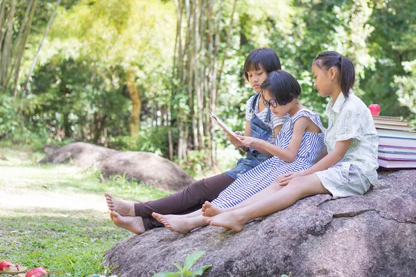 Üç çocuk bulmak için bilgi, doğal arka plan, eğitim ve bilimsel kavramlar kitap okumak niyetinde
